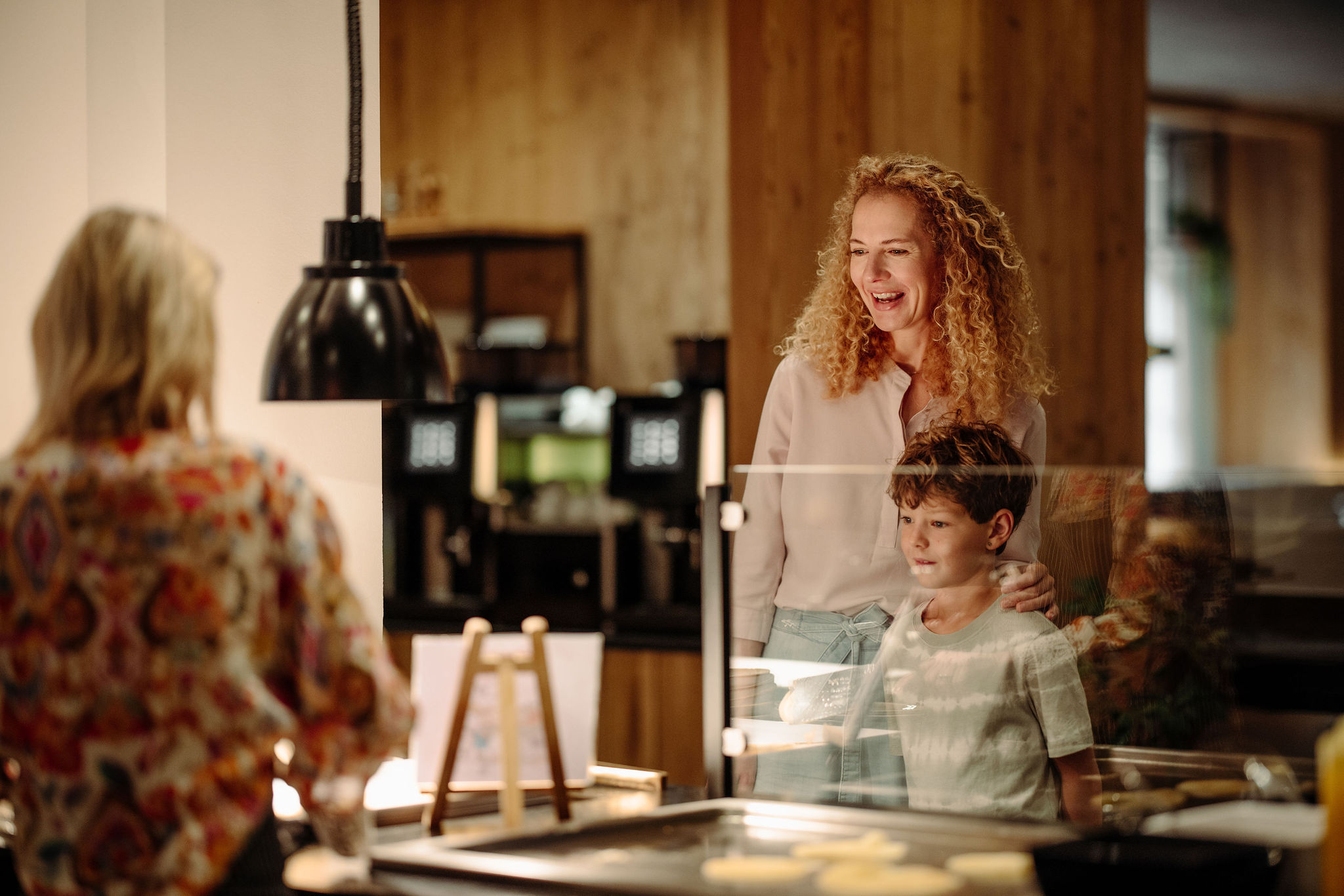 Eine Familie steht lächelnd am Buffet beim Frühstück