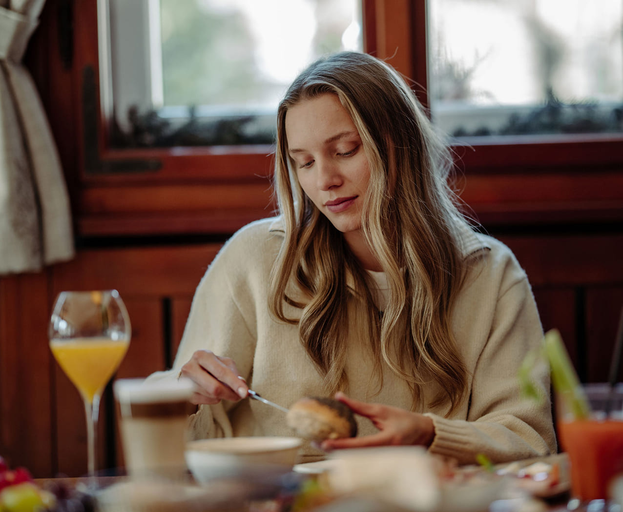 Frau genießt Frühstück mit frischen Säften im Reslwirt Flachau