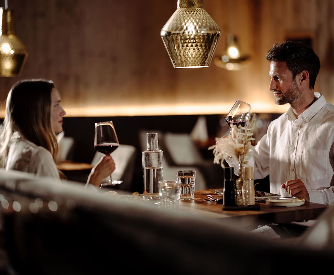 Paar genießt romantisches Abendessen mit Wein im Restaurant des Reslwirt Flachau