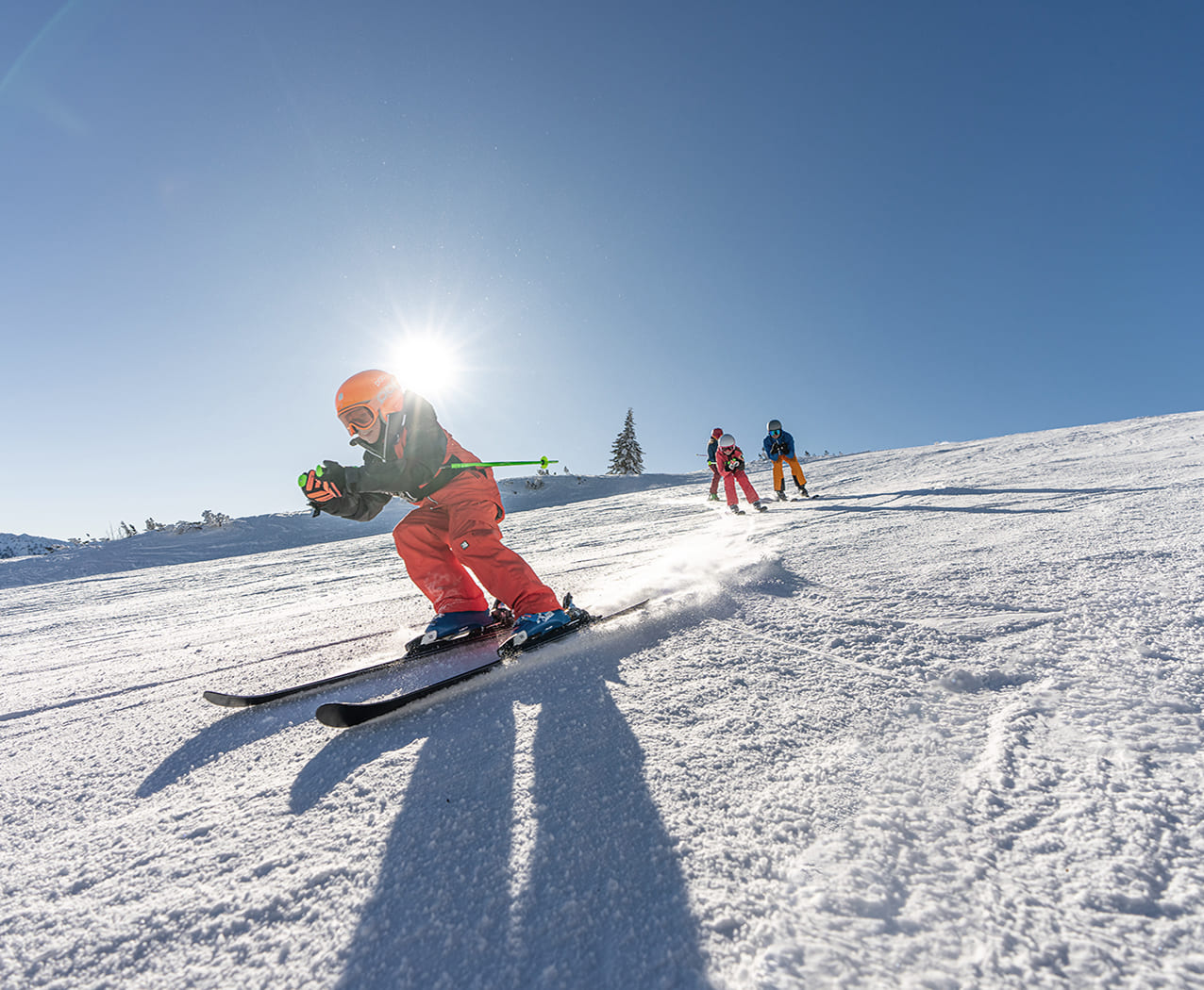 Skifahrer auf der Piste in Flachau bei Sonnenschein – Skiurlaub im Reslwirt