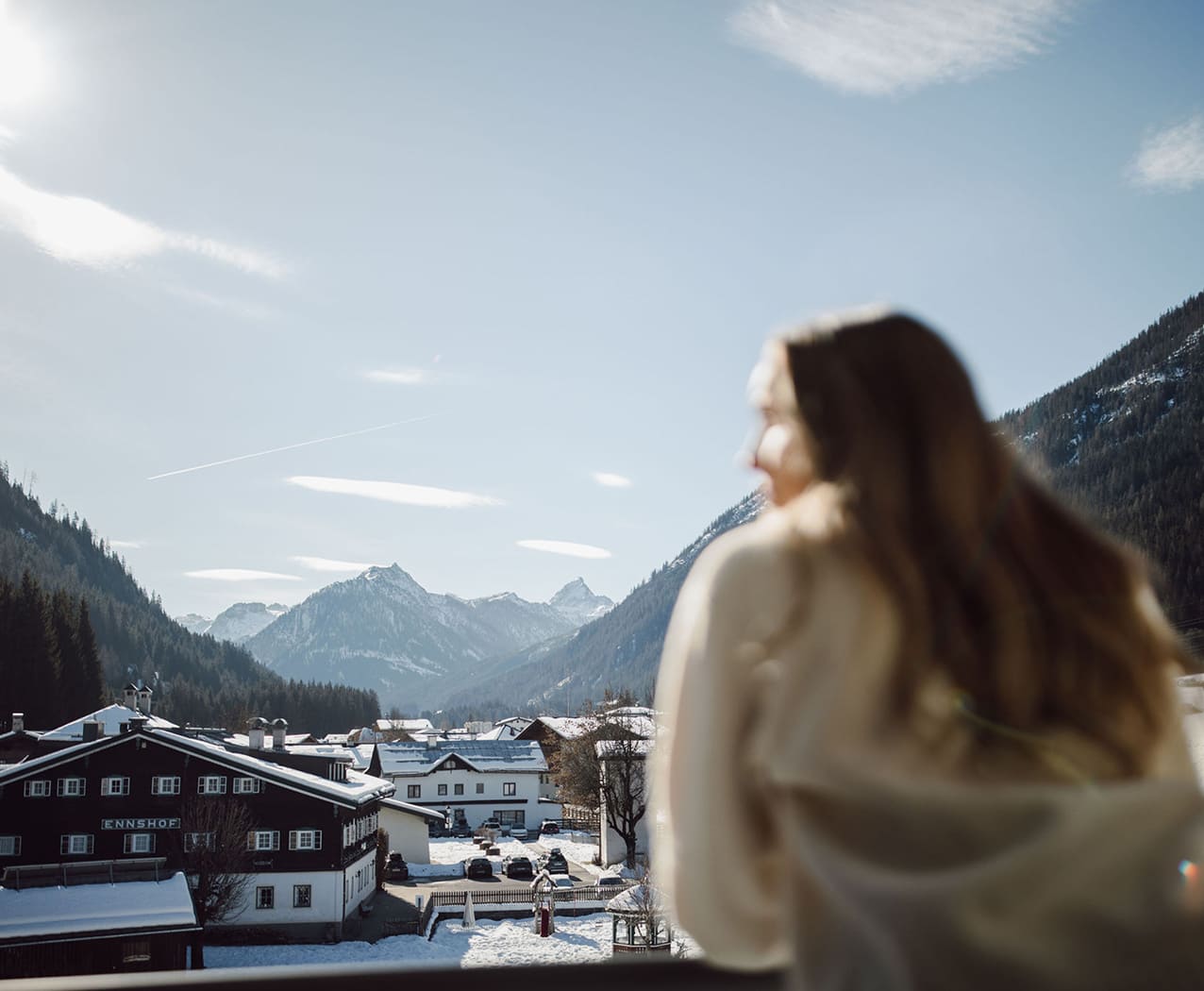 Frau genießt den Panoramablick auf Flachau und die verschneiten Berge vom Reslwirt