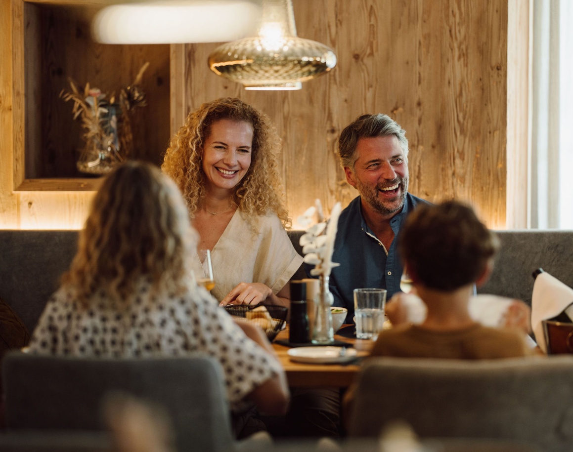 Eine fröhliche Familie sitzt zusammen an einem Tisch in einem gemütlichen Restaurant