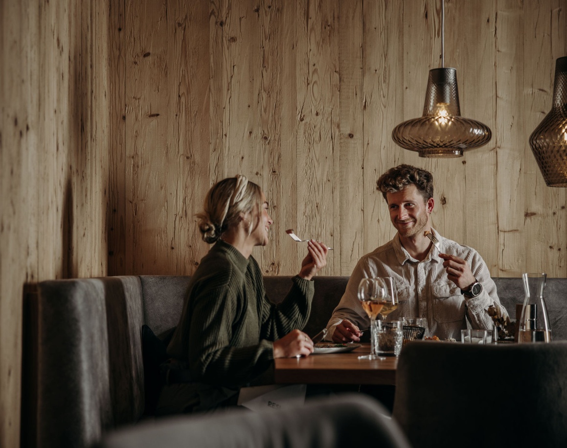 Ein Paar sitzt in einem gemütlichen Restaurant und genießt ein gemeinsames Abendessen